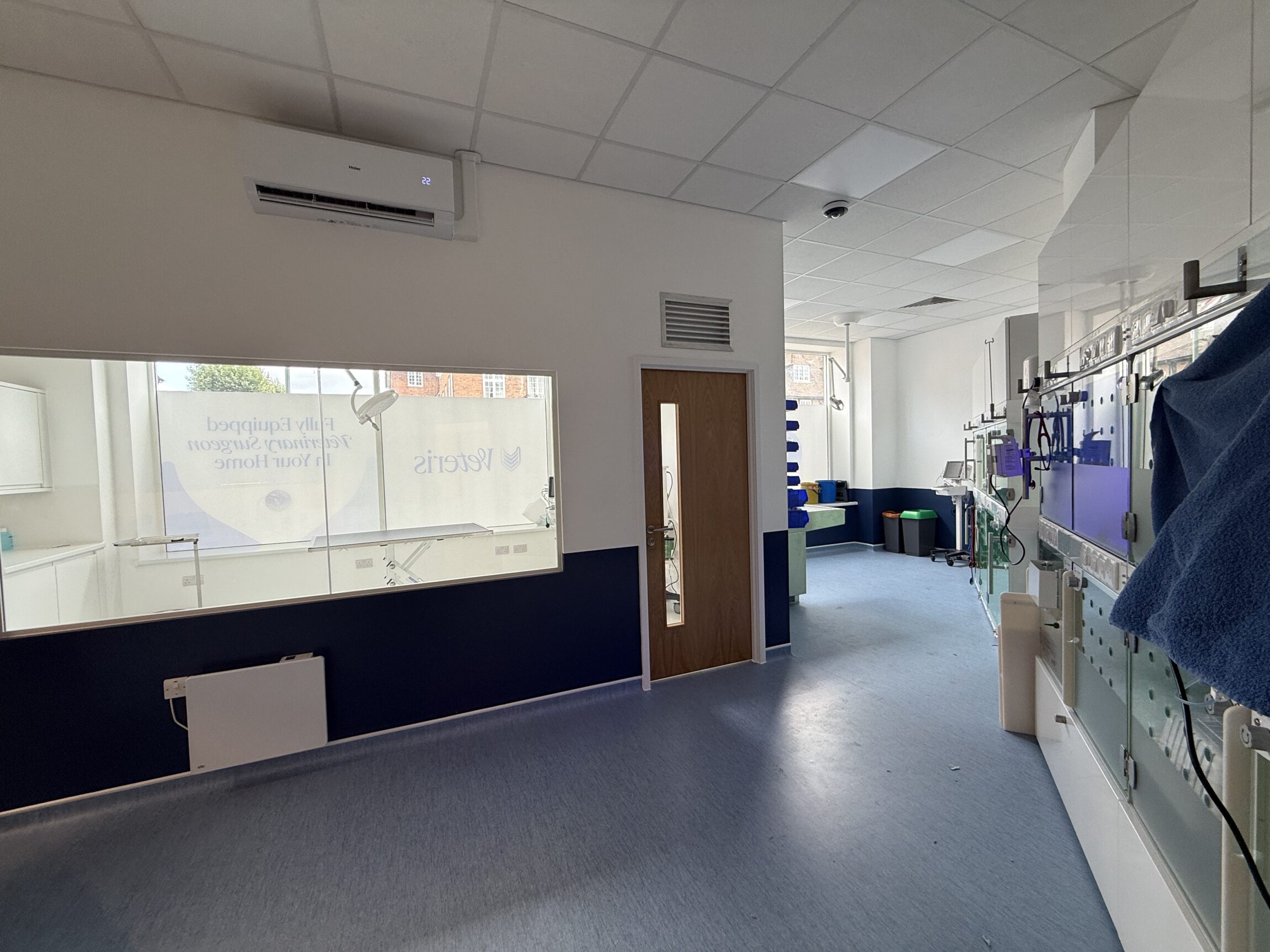 Interior of the Veteris veterinary practice in Temple Fortune, showing a clinical treatment area with veterinary equipment, examination room and blue flooring.